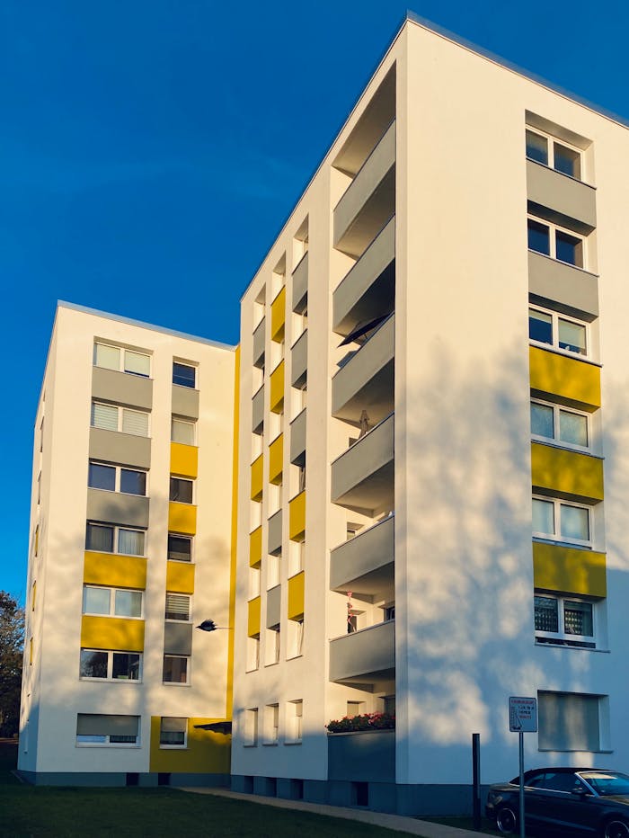 Contemporary apartment building with balconies under a clear blue sky.